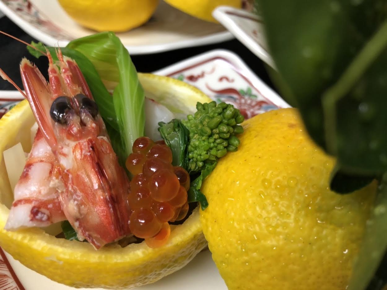 【日本料理みつわ】本日の一皿<p>新春の先付は、 旬の三宝柑を器に 鮮やかな車海老と、きらきらのいくら。 うるいと菜の花の美しいグリーンが春を伝えます。 みずみずしい三宝柑をきゅっと絞ってどうぞ。 穏やかな酸味と爽やかな甘みが広がります。</p>
